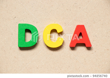 Color alphabet letter in word DCA (Abbreviation of Dollar-cost averaging) on wood background 94856740
