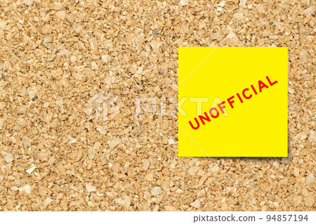 Yellow note paper with word unofficial on cork board background with copy space 94857194
