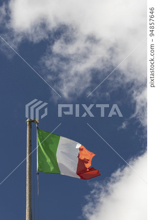 Italian flag blowing in the wind in the blue sky 94857646