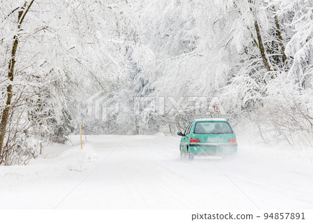green car on a snowy road, Orlicke Mountains, Czech Republic green car on a snowy road, Orlicke Mountains, Czech Republic 94857891