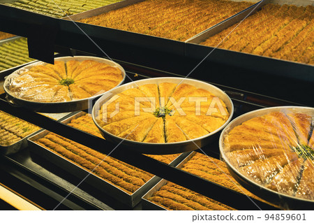 large plates of Arabic sweet baklava or baklawa on the shelves of store window large plates of Arabic sweet baklava or baklawa on the shelves of store window 94859601