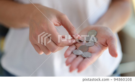 Georgian one lari coins in woman hand closeup Georgian one lari coins in woman hand closeup 94860108
