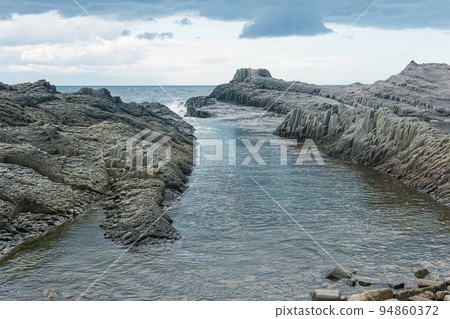coastal seascape with beautiful columnar basalt rocks at low tide 94860372