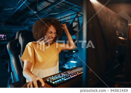 A young dark-skinned woman won a computer game. 94861489