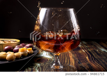 Cognac with ice sprinkled from a glass. Snack for cognac Cognac with ice sprinkled from a glass. Snack for cognac 94861715