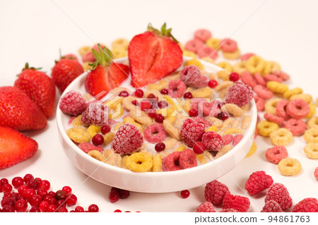 Corn rings with milk in a plate with berries and fruits, side view on a white background. The concept of quick breakfast cereals Corn rings with milk in a plate with berries and fruits, side view on a white background. The concept of quick breakfast cereals 94861763