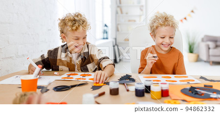 Cute children boys making Halloween home decorations Cute children boys making Halloween home decorations 94862332