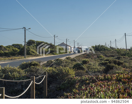 Zambujeira do Mar, Odemira, Portugal, October 27, 2021: Asphalt road leading to small resort town with sign of village entrance 94862504