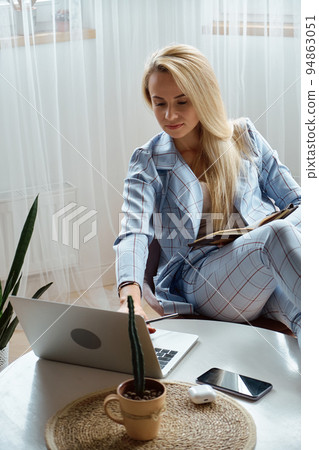 Young woman using laptop sitting at home office desk, remote work at home 94863051