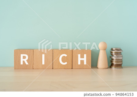 A block written as RICH, a doll and a coin 94864153