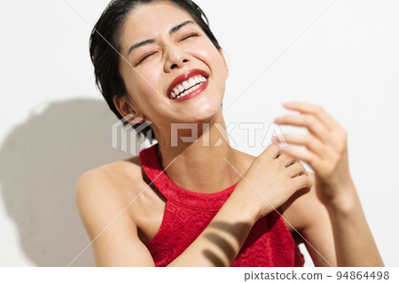 Young woman with short hair in a red dress Young woman with short hair in a red dress 94864498