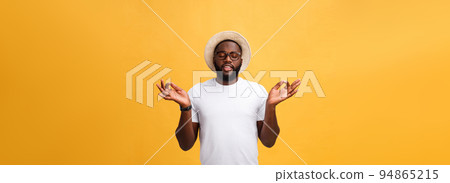 Closeup portrait of happy handsome, young man in meditation yoga mode, isolated on yellow background. Stress relief techniques concept. Closeup portrait of happy handsome, young man in meditation yoga mode, isolated on yellow background. Stress relief techniques concept. 94865215