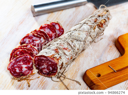 Piacenza salami cut in slices on a wooden surface, close-up Piacenza salami cut in slices on a wooden surface, close-up 94866274