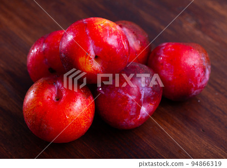 Sweet red plums on wooden table Sweet red plums on wooden table 94866319