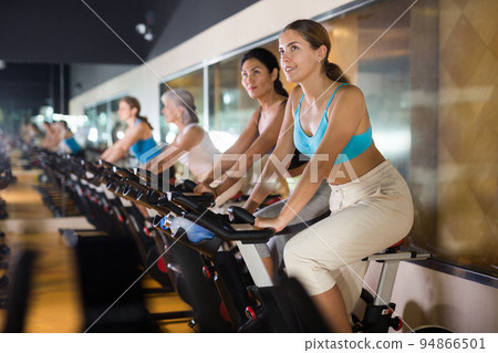 Woman taking indoor cycling class at gym 94866501