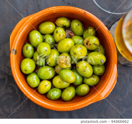 Trickle of pickled green olives on plate 94866662