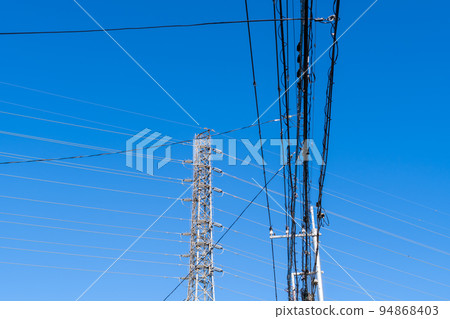 Power transmission tower a-1 that supports the intricate wires and high-voltage transmission lines in the residential area Power transmission tower a-1 that supports the intricate wires and high-voltage transmission lines in the residential area 94868403
