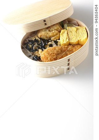 Nori bento with dashi-rolled omelet and scissors cutlet photographed against a white background 94868404