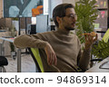 3d game artist works at a computer in the office and eats a big pizza  94869314
