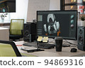 Designer's computer on table with a 3D model of a dog robot on a monitor screen 94869316