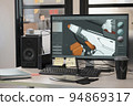 Designer's computer on table with a 3D model of a dog robot on a monitor screen 94869317