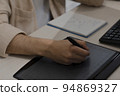 Close-up of the artist's hands of a designer drawing with a stylus on tablet 94869327