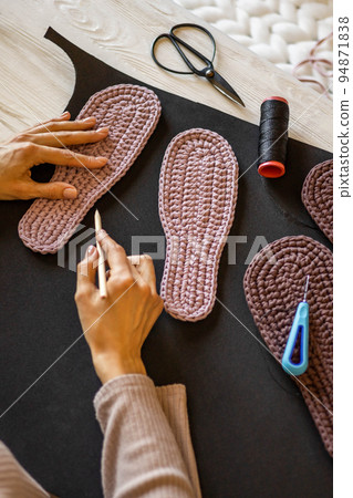 Female knitted clothes and shoes designer sketching drawing sample domestic slippers sole on fabric 94871838