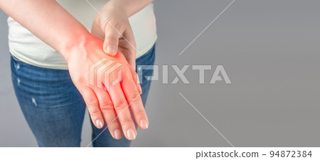 Carpal tunnel syndrome, arthritis, neurological disease concept. Numbness of hand. Closeup of female arms holding his painful wrist caused by prolonged work on computer, laptop. copy space 94872384
