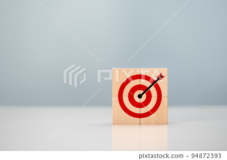 Initiation for planning to reach target. Darts target aim icon on wooden cubes with grey background. Focus on goal and achieve successful business. Copy space. Initiation for planning to reach target. Darts target aim icon on wooden cubes with grey background. Focus on goal and achieve successful business. Copy space. 94872393