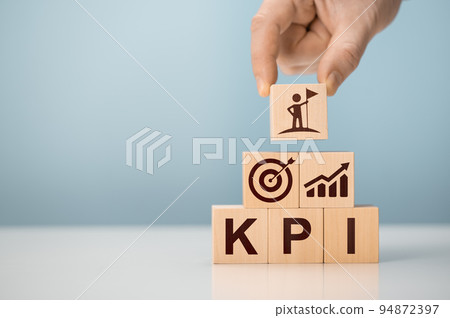KPI - Key Performance Indicator. Businessman holds cube with KPI, KPI key performance indicator increase optimisation business. Business planning and measure success, target achievement. KPI - Key Performance Indicator. Businessman holds cube with KPI, KPI key performance indicator increase optimisation business. Business planning and measure success, target achievement. 94872397