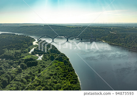 aerial photographs from an airplane window. airplane flight over river with bridge at summer sunset 94873593