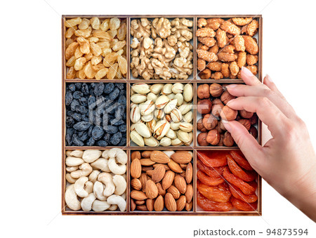 Hand with assorted nuts and dried fruit collection. Different superfoods. Vegetarian snack of different nuts. organic mixed nuts background 94873594