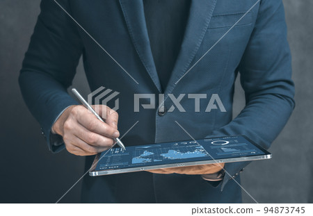 Businessman using tablet analyzing sales data and economic growth graph chart. Business strategy. Tablet and business graphics statistics and analytics. digital transformation Businessman using tablet analyzing sales data and economic growth graph chart. Business strategy. Tablet and business graphics statistics and analytics. digital transformation 94873745