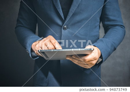 Businessman holding tablet computer on dark background. Business growth, planing and strategy concept. copy space Businessman holding tablet computer on dark background. Business growth, planing and strategy concept. copy space 94873749