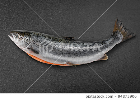 Fresh raw salmon, red fish on black stone background. Creative layout made of fish, top view. Raw salmon carcass. Sea fish, healthy food Fresh raw salmon, red fish on black stone background. Creative layout made of fish, top view. Raw salmon carcass. Sea fish, healthy food 94873906
