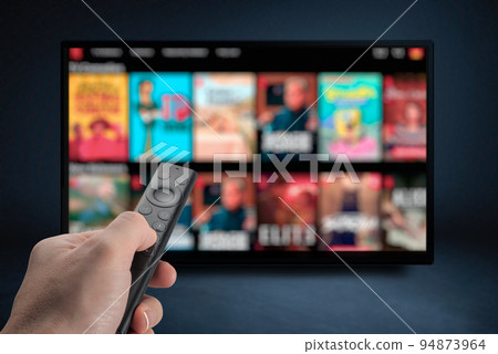 Tv online. Television streaming video. Male hand holding TV remote control. Multimedia streaming concept. VoD content provider. Video service with internet streaming multimedia shows, series. 94873964