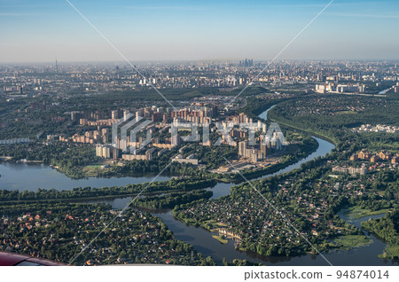 aerial photo of large city from an airplane window. view of city of Moscow through window from plane aerial photo of large city from an airplane window. view of city of Moscow through window from plane 94874014