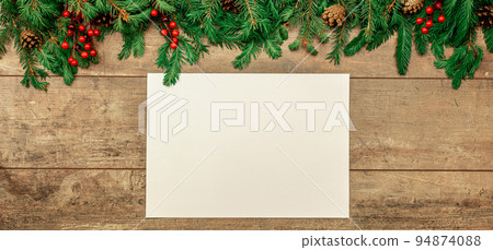 Christmas rustic mockup. sheet of white paper lies on an old table decorated with Christmas fir branches, red berries and cones. wide banner Christmas rustic mockup. sheet of white paper lies on an old table decorated with Christmas fir branches, red berries and cones. wide banner 94874088