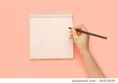 Mockup notepad. woman hand with pencil next to an empty blank white notepad. Women holding a pen writing a notebook. Recording concept. Woman writing in notepad. 94874099