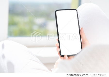 Cropped shot view of woman hands holding smart phone with blank copy space screen for text message or information content,. female reading text message on cell telephone at home Cropped shot view of woman hands holding smart phone with blank copy space screen for text message or information content,. female reading text message on cell telephone at home 94874300