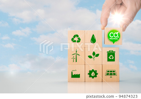 Net zero and carbon neutral concept. Put wooden cubes with green net zero icon. Hand put wooden cubes with green net zero icon and green icon on blue sky background. Net zero and carbon neutral concept. Put wooden cubes with green net zero icon. Hand put wooden cubes with green net zero icon and green icon on blue sky background. 94874323