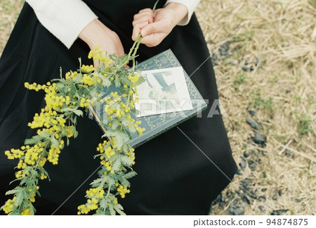 Woman with mimosa bouquet and polaroid photo and book Woman with mimosa bouquet and polaroid photo and book 94874875