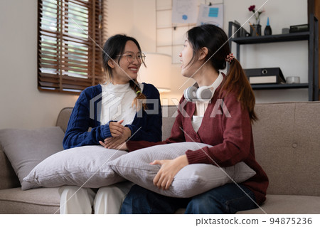 Two Young woman cheering together for sport on TV in cozy living room at home 94875236