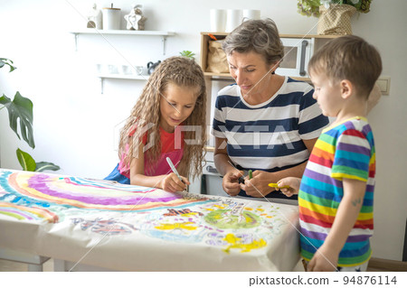 Family mother and kids drawing art picture on paper with multicolored chalks enjoy weekend Family mother and kids drawing art picture on paper with multicolored chalks enjoy weekend 94876114