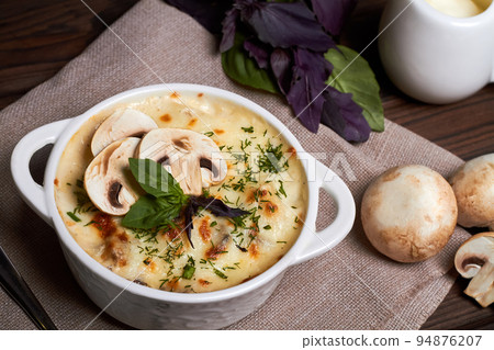 Chicken julienne with cheese, mushrooms and herbs in white plate on wooden board Chicken julienne with cheese, mushrooms and herbs in white plate on wooden board 94876207