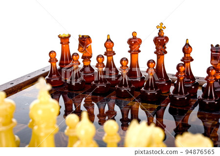 Natural amber different chess pieces figures standing on brown stone board. Close up game concept competition, Classic Gambit Tournament of confrontation. Natural amber different chess pieces figures standing on brown stone board. Close up game concept competition, Classic Gambit Tournament of confrontation. 94876565