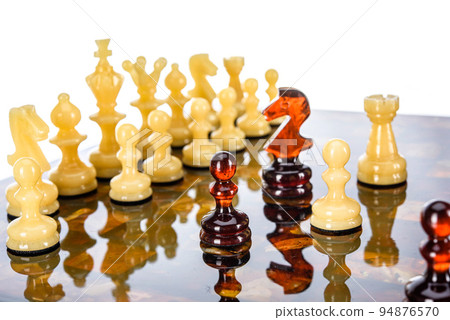 Natural amber different chess pieces figures standing on brown stone board. Close up game concept competition, Classic Gambit Tournament of confrontation. Natural amber different chess pieces figures standing on brown stone board. Close up game concept competition, Classic Gambit Tournament of confrontation. 94876570
