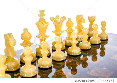 Natural amber different chess pieces figures standing on brown stone board. Close up game concept competition, Classic Gambit Tournament of confrontation. Natural amber different chess pieces figures standing on brown stone board. Close up game concept competition, Classic Gambit Tournament of confrontation. 94876571