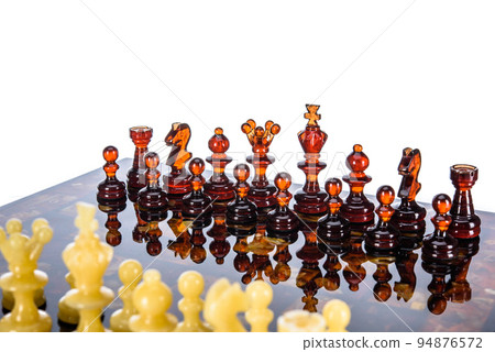 Natural amber different chess pieces figures standing on brown stone board. Close up game concept competition, Classic Gambit Tournament of confrontation. Natural amber different chess pieces figures standing on brown stone board. Close up game concept competition, Classic Gambit Tournament of confrontation. 94876572