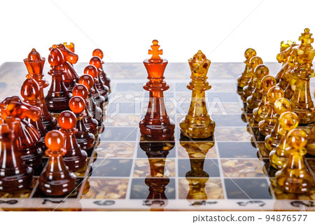Natural amber different chess pieces figures standing on brown stone board. Close up game concept competition, Classic Gambit Tournament of confrontation. Natural amber different chess pieces figures standing on brown stone board. Close up game concept competition, Classic Gambit Tournament of confrontation. 94876577